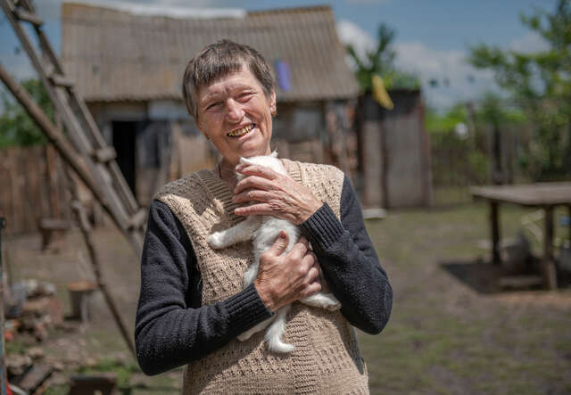 Anna stands holding her kitten.